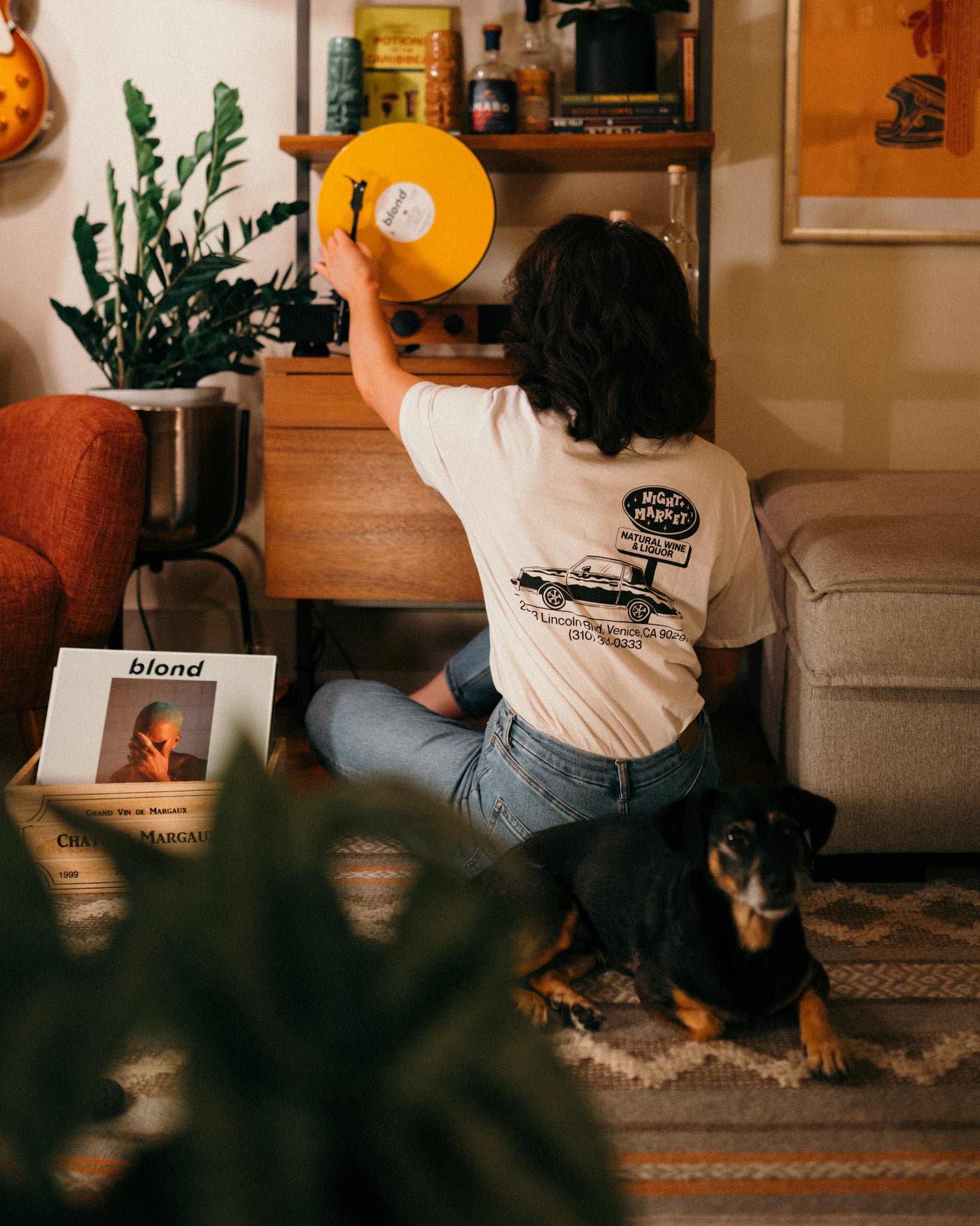Girl wearing a Night Marketing restaurant t-shirt while listening to records.